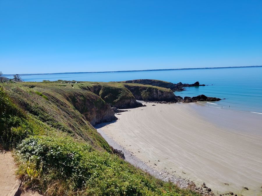 En contrebas, une plage cachée au creux des terres.